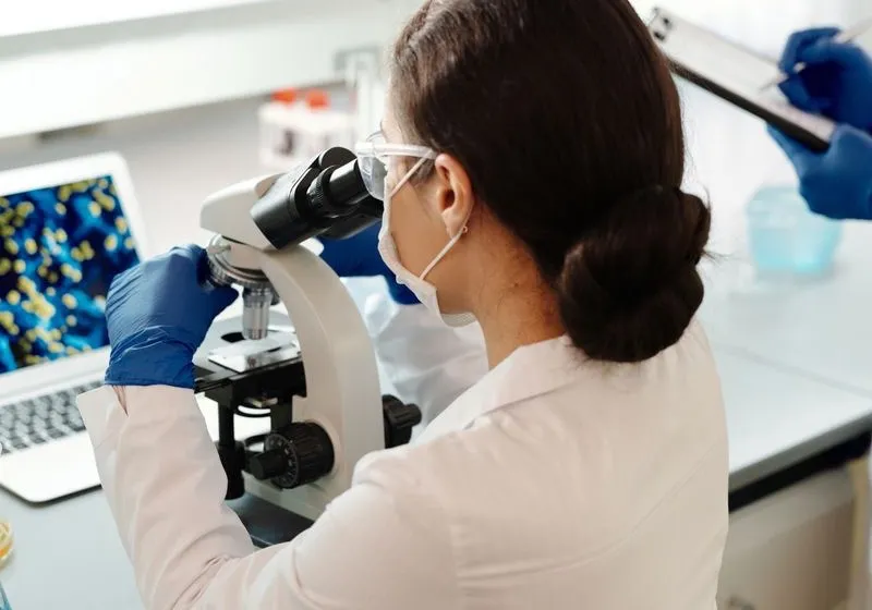 Boncmester képzés — patológiai laboratóriumi szakember szövettani mintát vizsgál mikroszkóppal